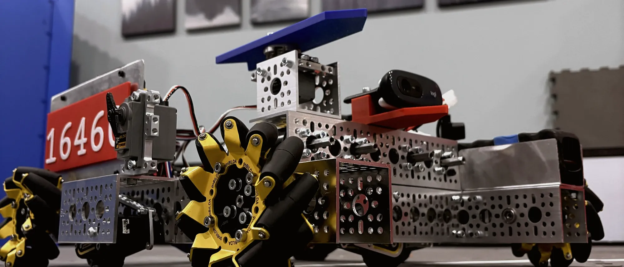 A competition robot on a contest field: aluminium chassis, mecanum wheels and a team number board.